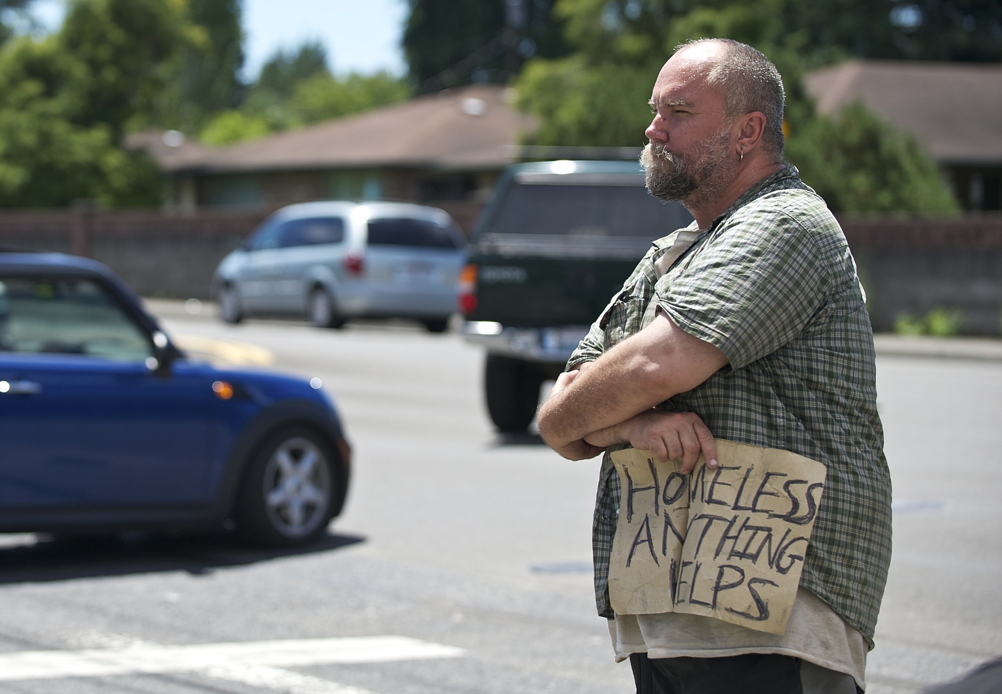 Paul Erickson, 40, stands at Northeast 81st Street and Hazel Dell Avenue with a sign that reads u201cHomeless anything helpsu201d while panhandling.