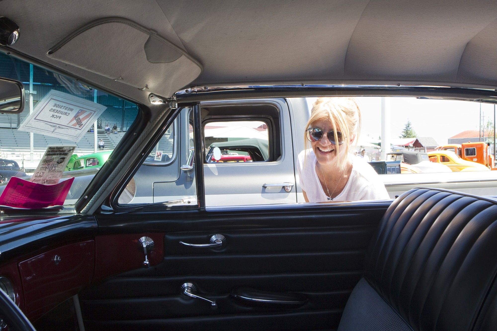 Amy Schlueter peeks inside a refurbished car Sunday at the Northwest Street Rod Nationals Plus Show at the Clark County Event Center at the Fairgrounds.
