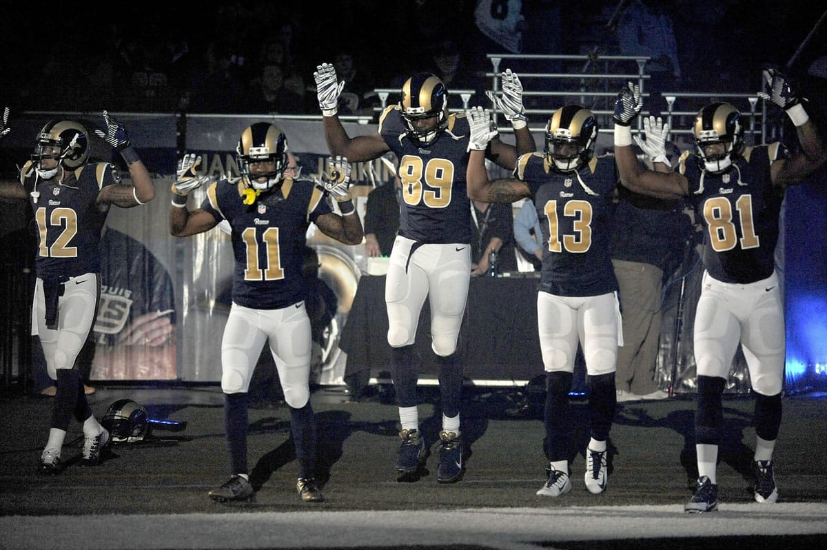 Members of the St. Louis Rams raise their arms in awareness of the events in Ferguson, Mo.,  as they walk onto the field during introductions before an NFL football game against the Oakland Raiders, Sunday, Nov. 30, 2014, in St. Louis. From left are Stedman Bailey (12), Tavon Austin (11), Jared Cook, (89) Chris Givens (13) and Kenny Britt (81).