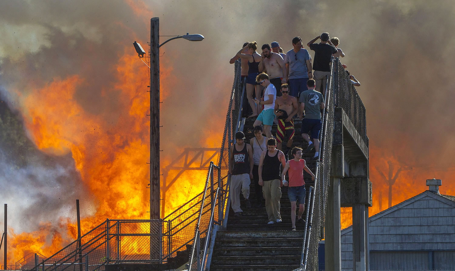 Onlookers watch the Civic Stadium burn in Eugene, Ore., on Monday.