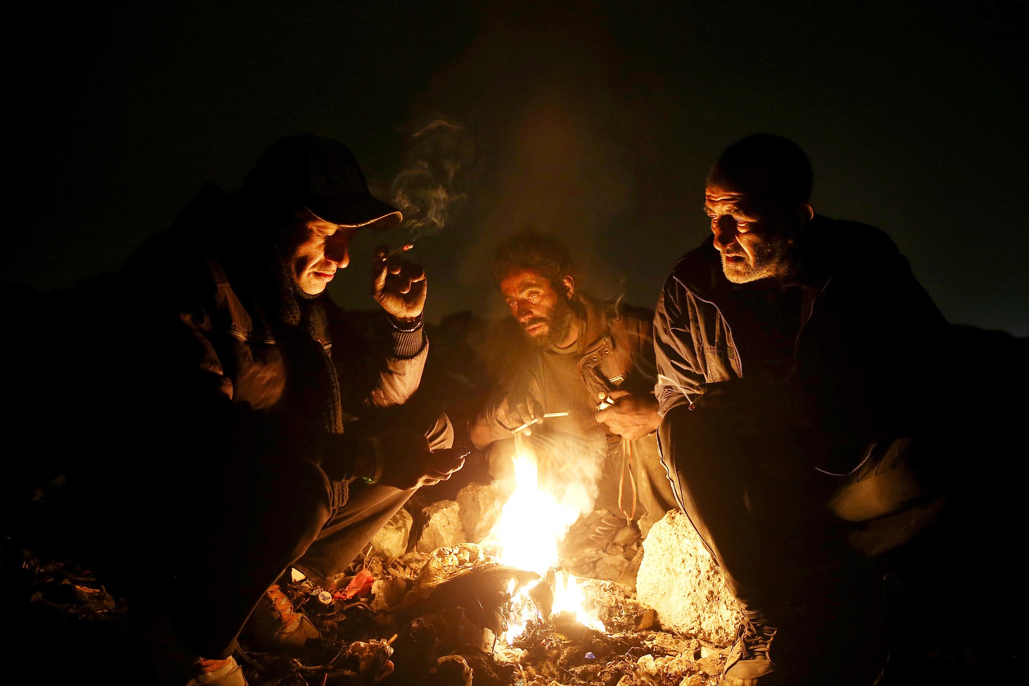 Drug addicts huddle around a fire to warm themselves Wednesday in a suburb of Tehran, Iran.