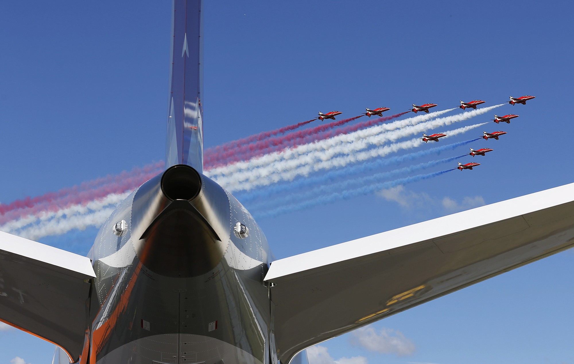 The Royal Air Force Red Arrows aerobatic display team perform a fly past Farnborough Airport on Monday to open the International Air Show, Farnborough, England.