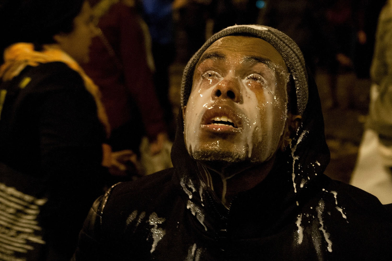 A protestor pours milk in his eyes after being tear gassed by Seattle police at the Interstate 5 entrance on Cherry Street in Seattle on Monday night.