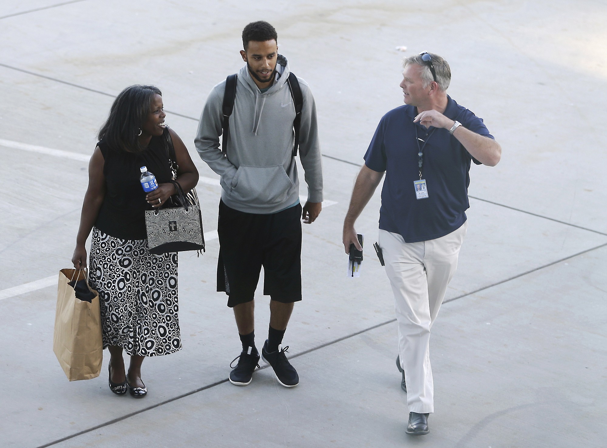 Anthony Sadler, center, who helped stop a terror attack on a train traveling from Amsterdam to Paris, walks to a waiting vehicle Tuesday at Sacramento International Airport in Sacramento, Calif.
