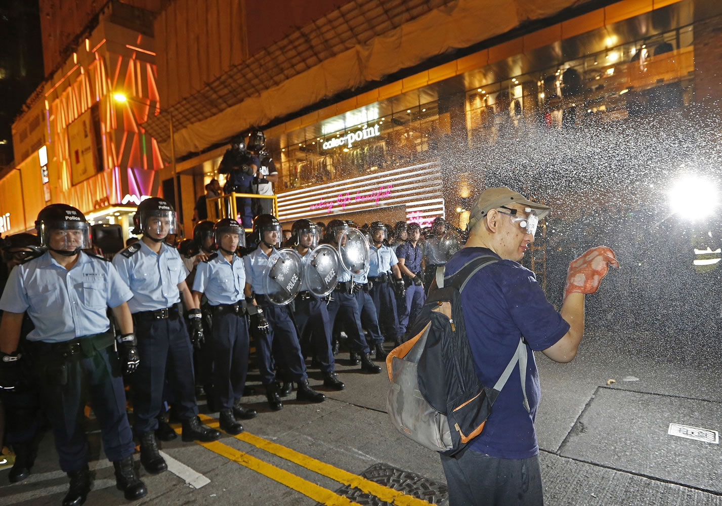 A demonstrator gets sprayed with pepper spray by the police as demonstrators refused to leave after workers began clearing away barricades at an occupied area in Mong Kok district of Hong Kong on Tuesday.
