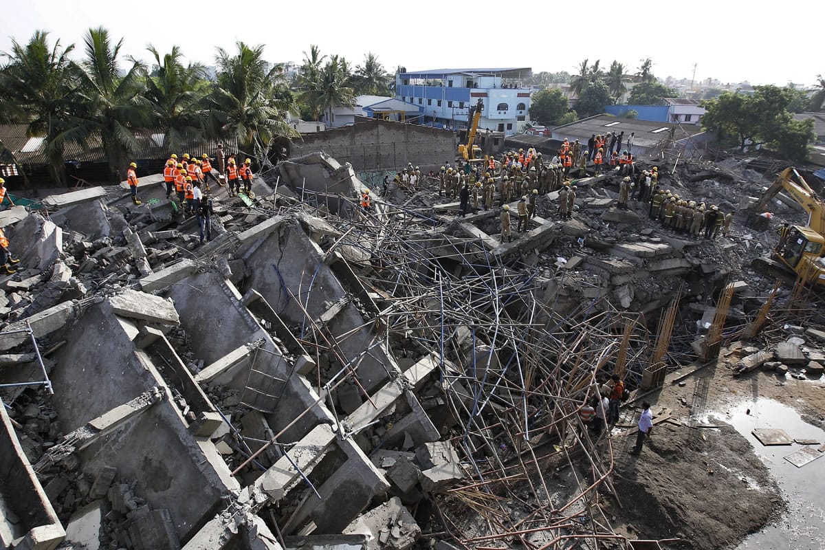 Rescuers search Sunday for workers believed buried in the rubble of a building that collapsed on the outskirts of Chennai, India. Police said dozens of workers have been pulled out so far and the search is continuing.