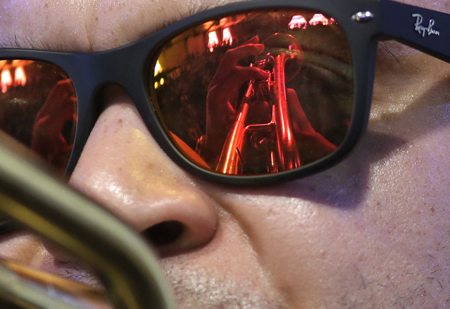 The hands and trumpet of jazz recording artist Irvin Mayfield are reflected in his glasses as he performs Thursday at the New Orleans Jazz and Heritage Festival.