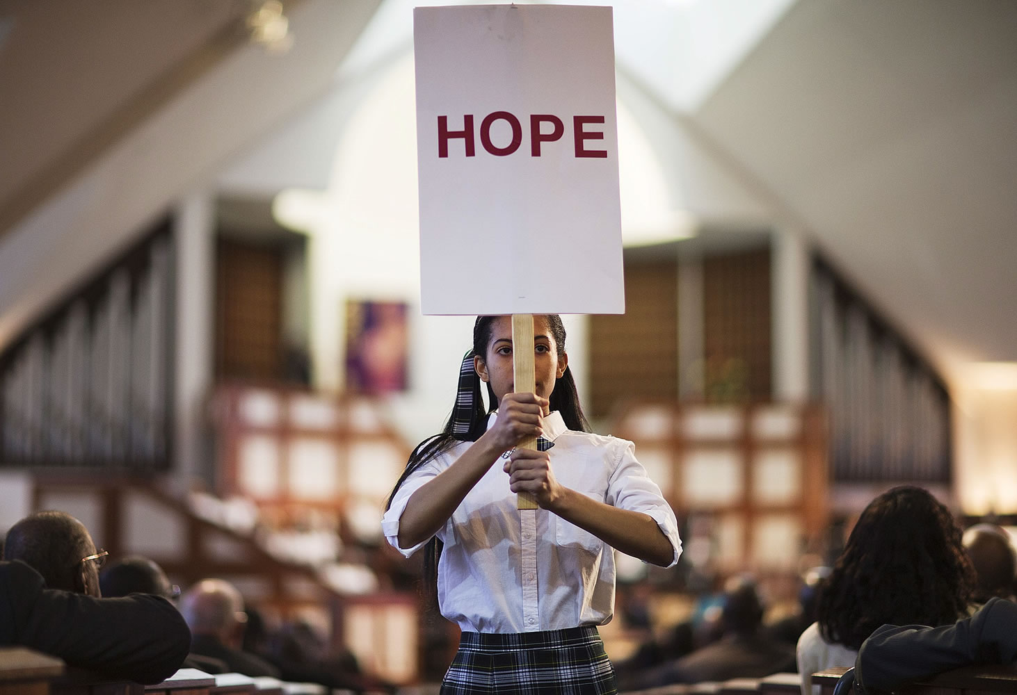 Jaiya Smith carries a sign down the aisle during a service honoring Rev. Martin Luther King Jr. at Ebenezer Baptist Church, where King preached, Monday, Jan. 19, 2015, in Atlanta.