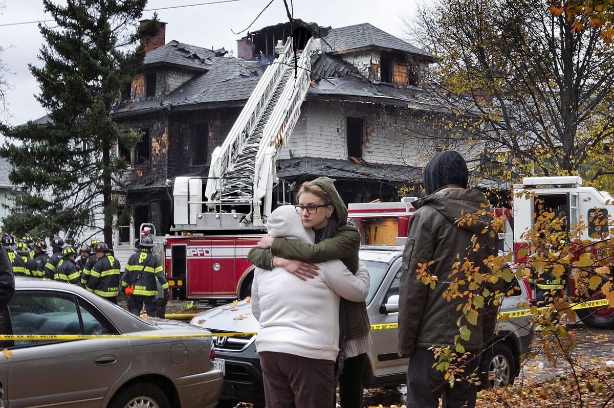Friends of a victim of a fatal apartment building fire console one another other Saturday in Portland, Maine. A fire swept through a two-apartment building housing students from the University of Southern Maine on Saturday morning, killing four people and critically injuring one, authorities said.