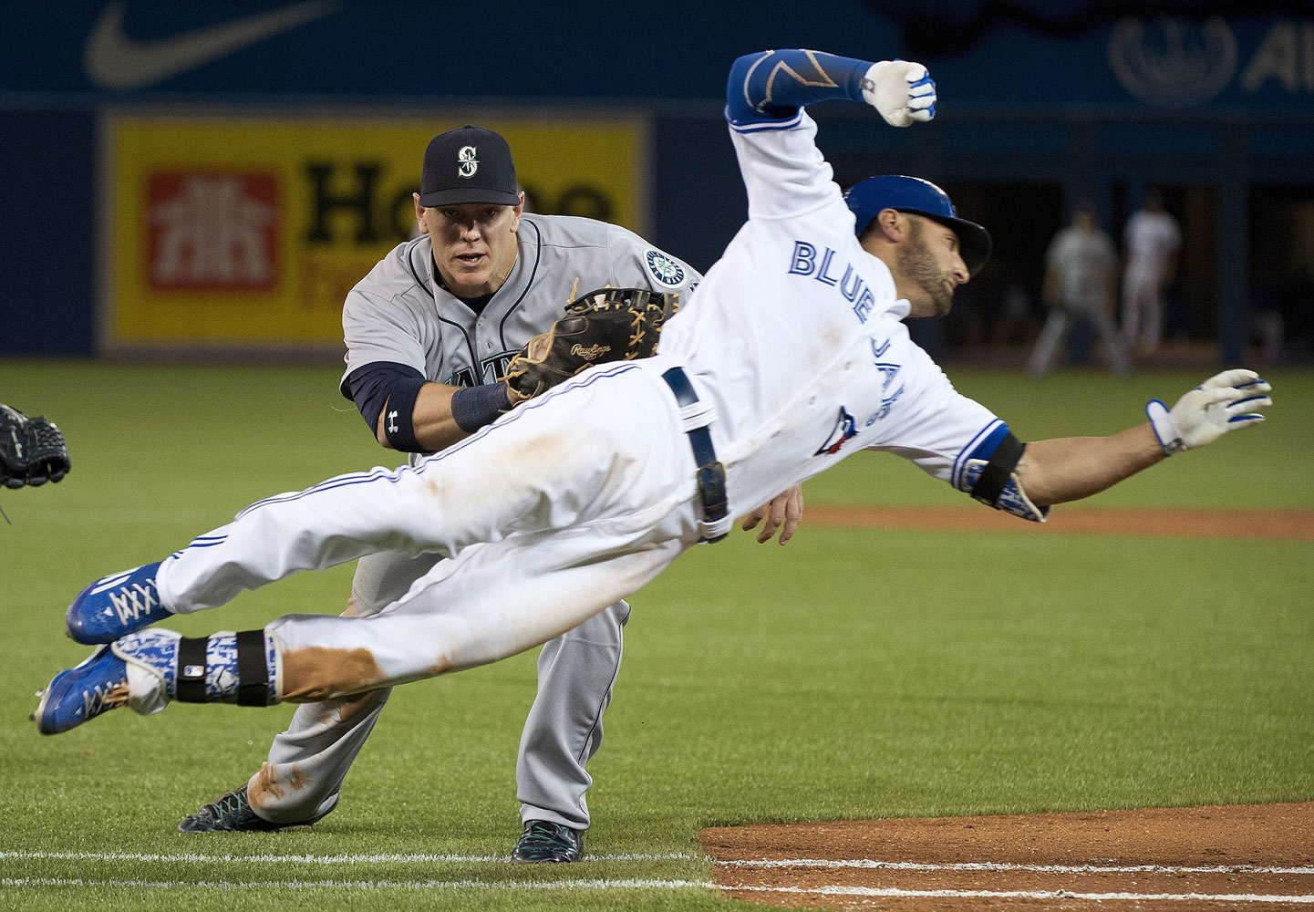 Toronto Blue Jays' Kevin Pillar, right, makes a diving attempt but gets tagged out at first base by Seattle Mariners first baseman Logan Morrison during the ninth inning in Toronto on Friday, May 22, 2015.