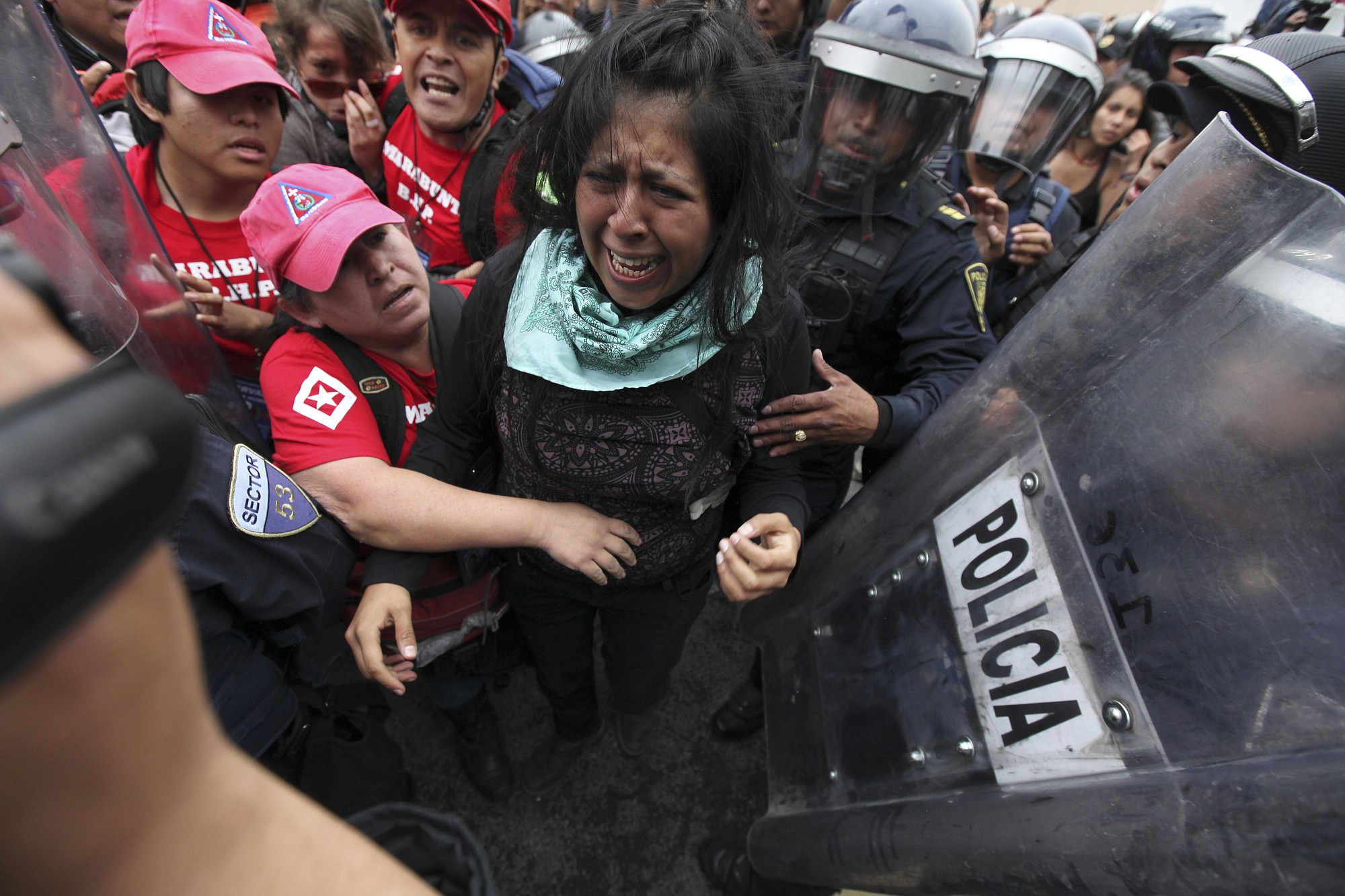 A protester cries as she is detained by police while human rights observers, left, try to reach her during a march Thursday near the airport in Mexico City.