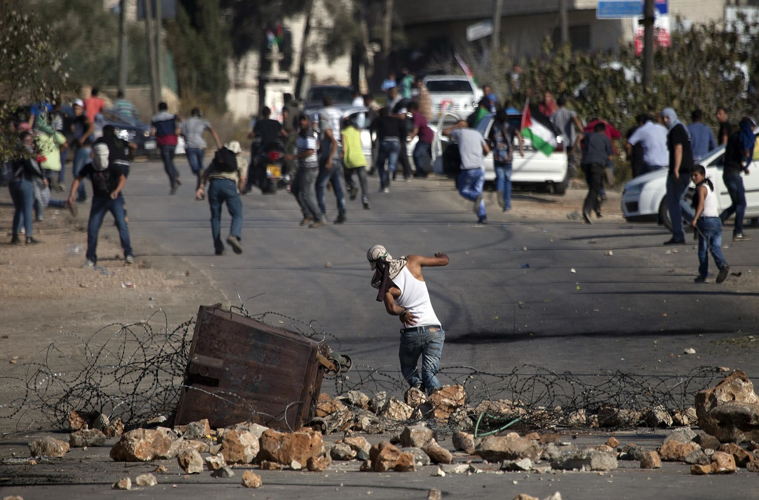 Palestinians run after a comrade is hit by a rubber coated metal bullet in the back during clashes with Israeli forces after the funeral for Palestinian-American, Orwah Hammad, 14, who was shot dead Friday.