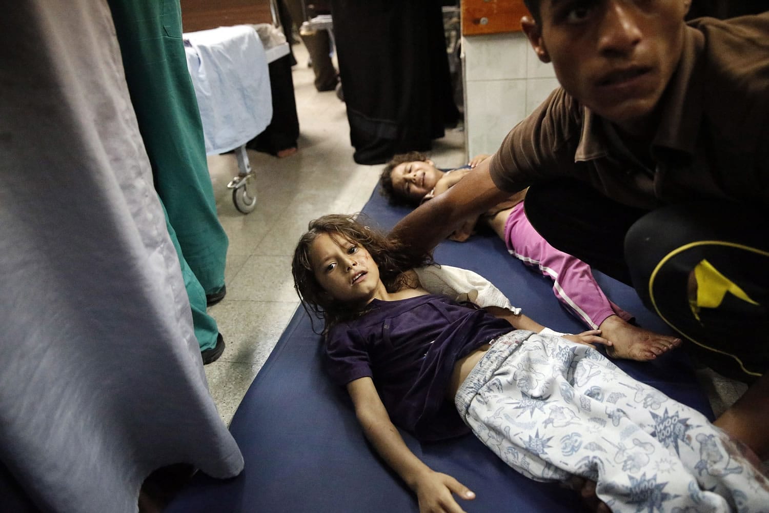 Palestinian children, wounded during fighting between Israeli forces and Hamas militants in Beit Hanoun, northern Gaza Strip, are treated on the floor of an emergency room Thursday at the Kamal Adwan hospital in Beit Lahiya.