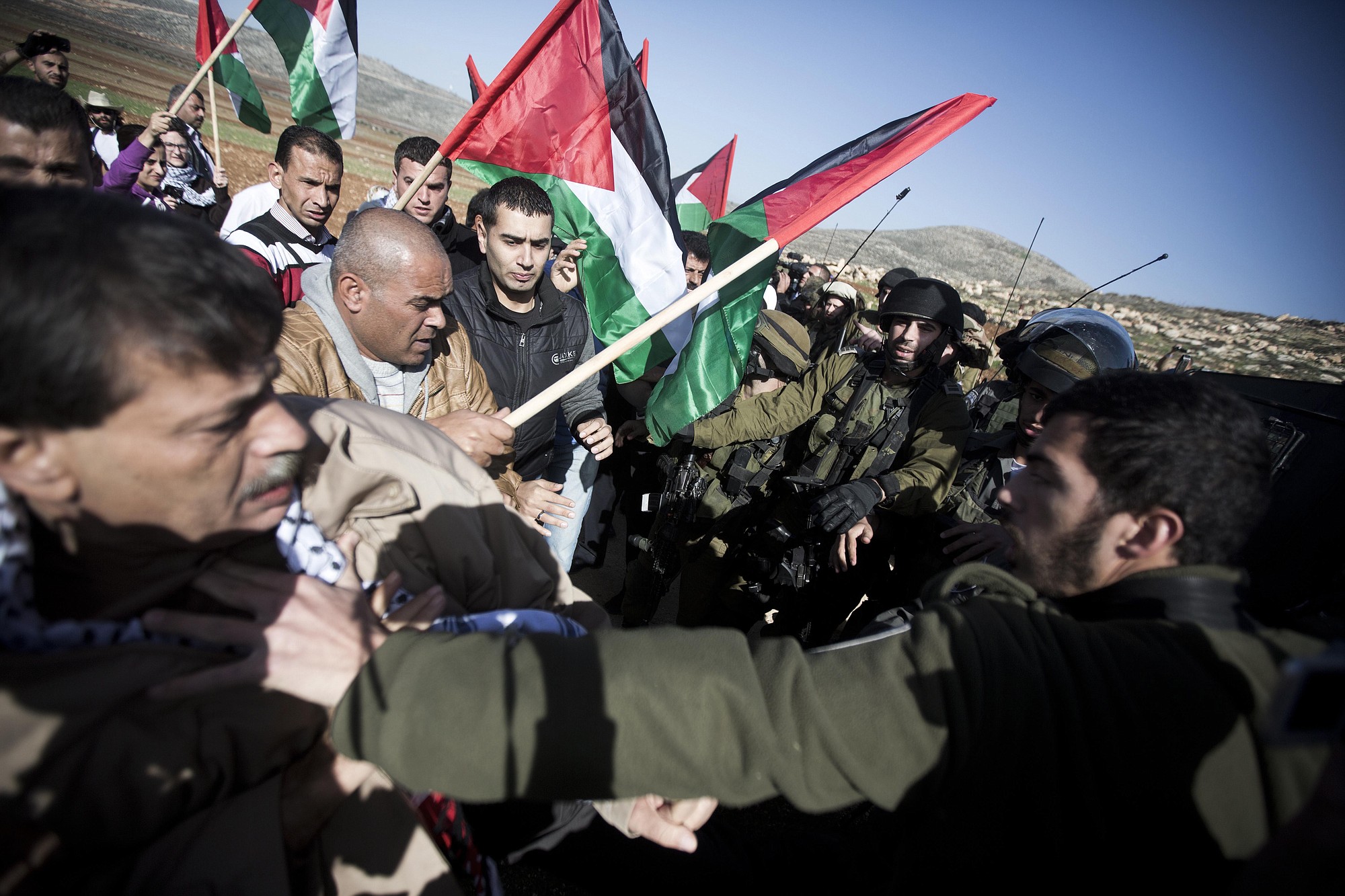 An Israeli soldier pushes Palestinian Cabinet member Ziad Abu Ain, left, during a protest in the village of Turmus Aya near the West Bank city of Ramallah on Wednesday.