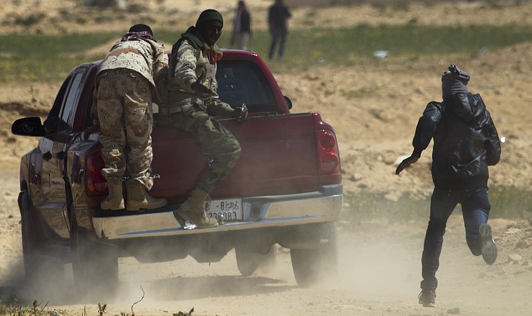 Libyan rebels run to take cover as mortars from Moammar Gadhafi's forces are fired on them on the frontline near Zwitina, the outskirts of the city of Ajdabiya, south of Benghazi, eastern Libya, Wednesday.