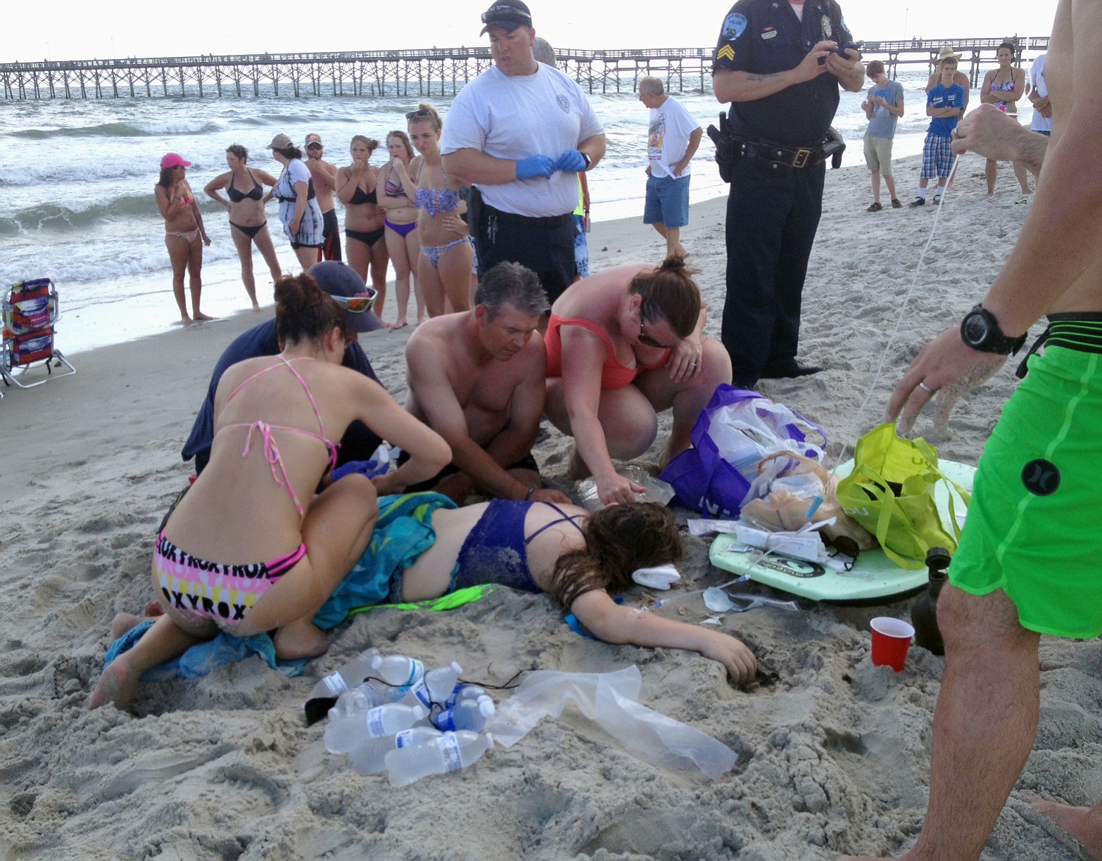 Emergency responders assist a teenage girl at the scene of a shark attack in Oak Island, N.C., Sunday.