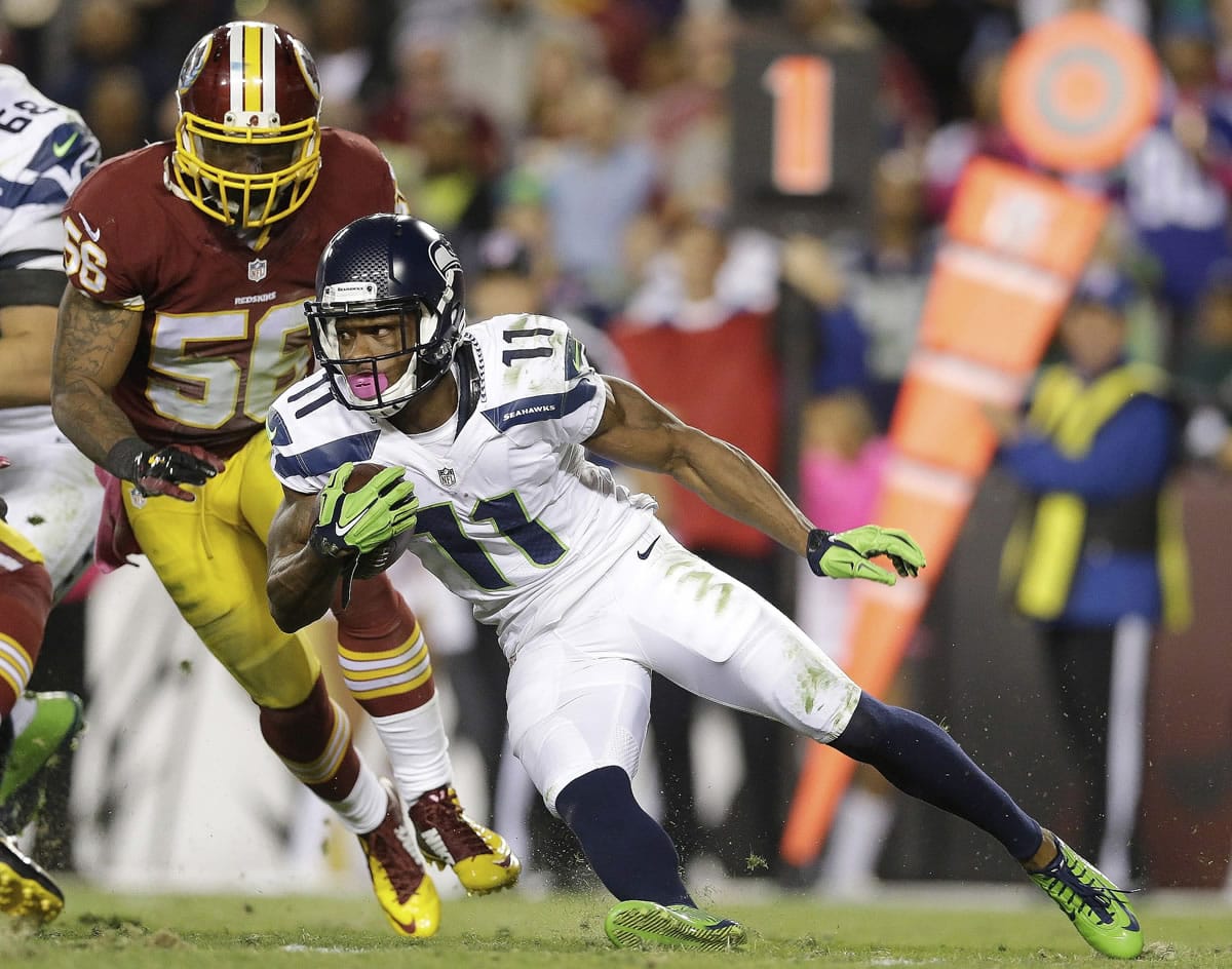 Seattle Seahawks wide receiver Percy Harvin (11) carries the ball past Washington Redskins inside linebacker Perry Riley (56) during the first half of an NFL football game in Landover, Md., Monday, Oct. 6, 2014.