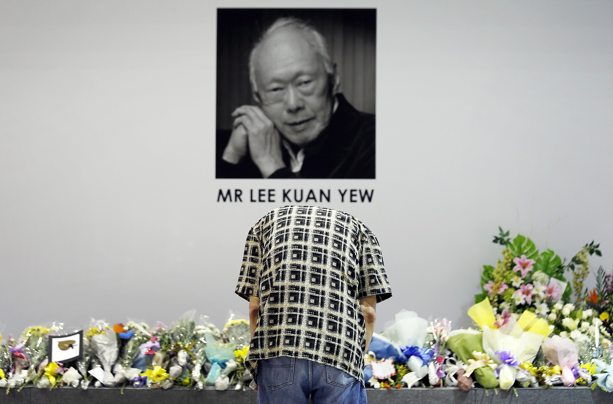 A man bows to pay his respects to the late Lee Kuan Yew at a community club where members of the public can gather to express their condolences Monday in Singapore.