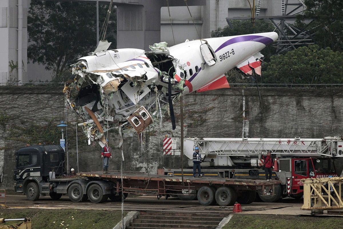 The main fuselage from TransAsia Airways Flight 235 is hoisted away in Taipei, Taiwan, on Thursday.