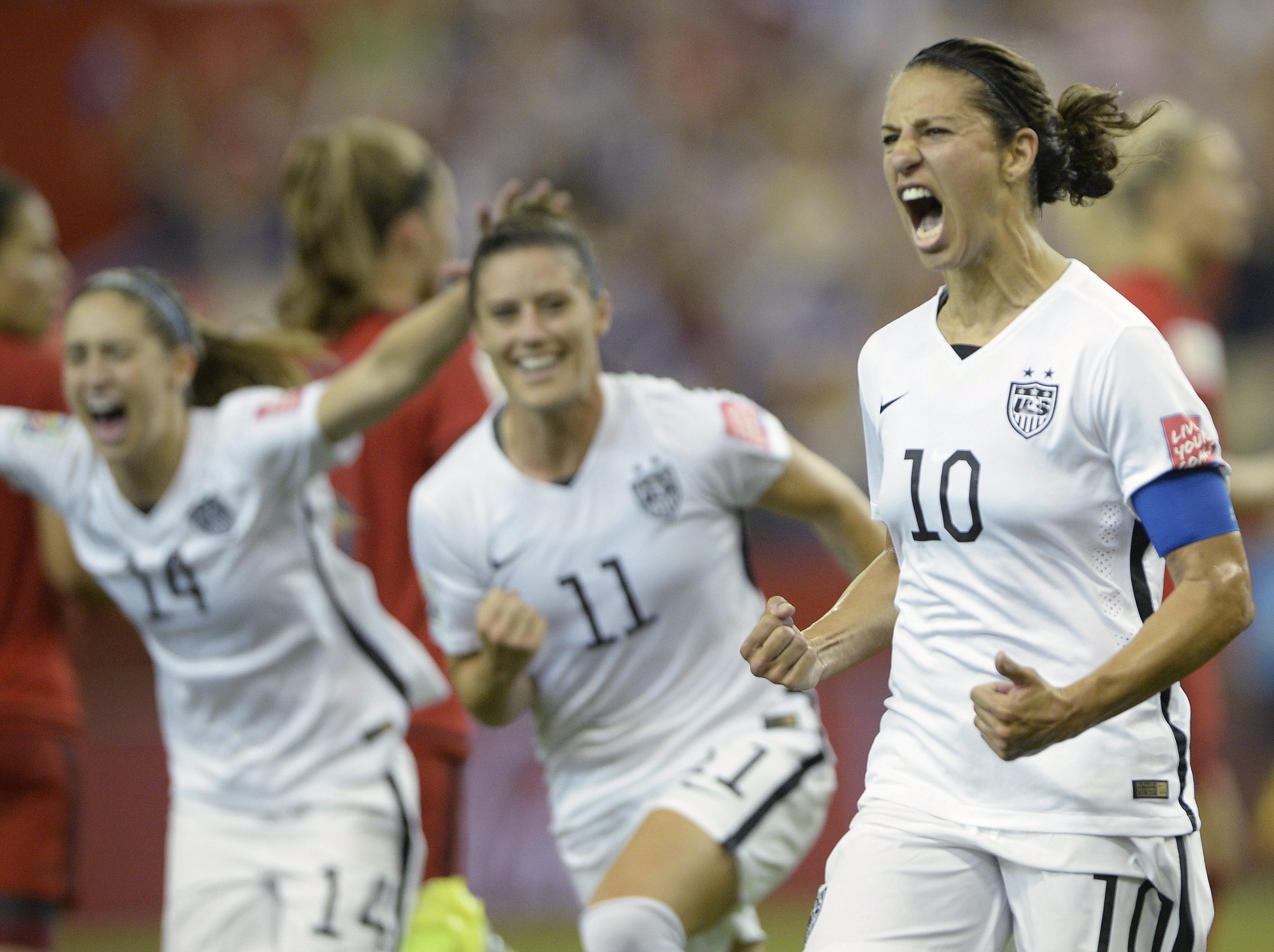 United States' Carli Lloyd (10) celebrates with teammates Ali Krieger (11) and Morgan Brian after scoring on a penalty kick against Germany during the second half of a semifinal in the Women's World Cup Tuesday in Montreal, Canada.