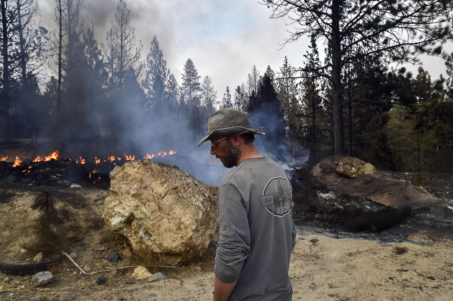 Lorne Brunson stands near the remains of his home, which was lost to a wildfire on Saturday near Coyote Canyon Sunday in Fruitland.