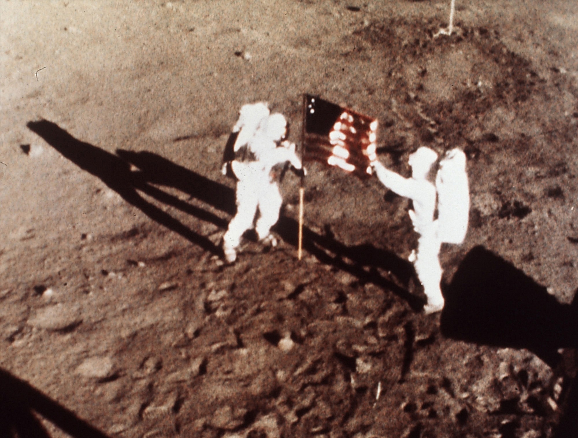 Apollo 11 astronauts Neil Armstrong and Edwin E. &quot;Buzz&quot; Aldrin, the first men to land on the moon, plant the U.S. flag on the lunar surface, July 20, 1969.