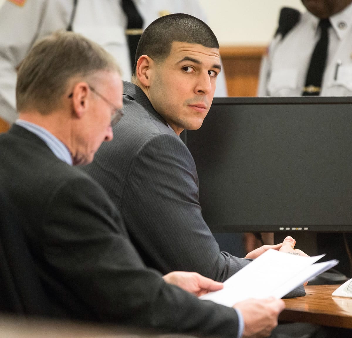 Former New England Patriots player Aaron Hernandez, right, glances towards the Lloyd family during his trial at Bristol County Superior Court in Fall River, Mass., on Tuesday.