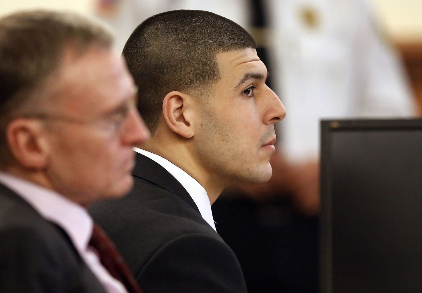 Former New England Patriots football player Aaron Hernandez, right, listens during his murder trial as defense attorney Charles Rankin, left, looks on Thursday in Fall River, Mass.