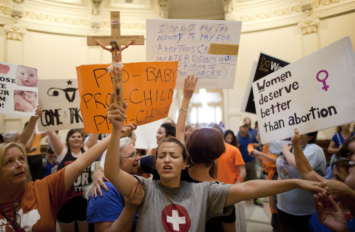 Anti-abortion rights supporter Katherine Aguilar holds a crucifix and prays while opponents and supporters of abortion rights gather in the State Capitol rotunda in Austin, Texas, on July 12, 2013.