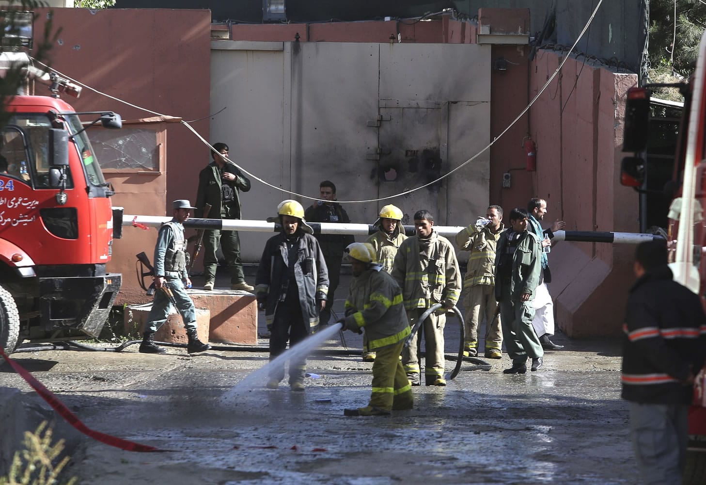 Afghan firefighters spray water near a guesthouse targeted in an attack by the Taliban on Wednesday in Kabul, Afghanistan.