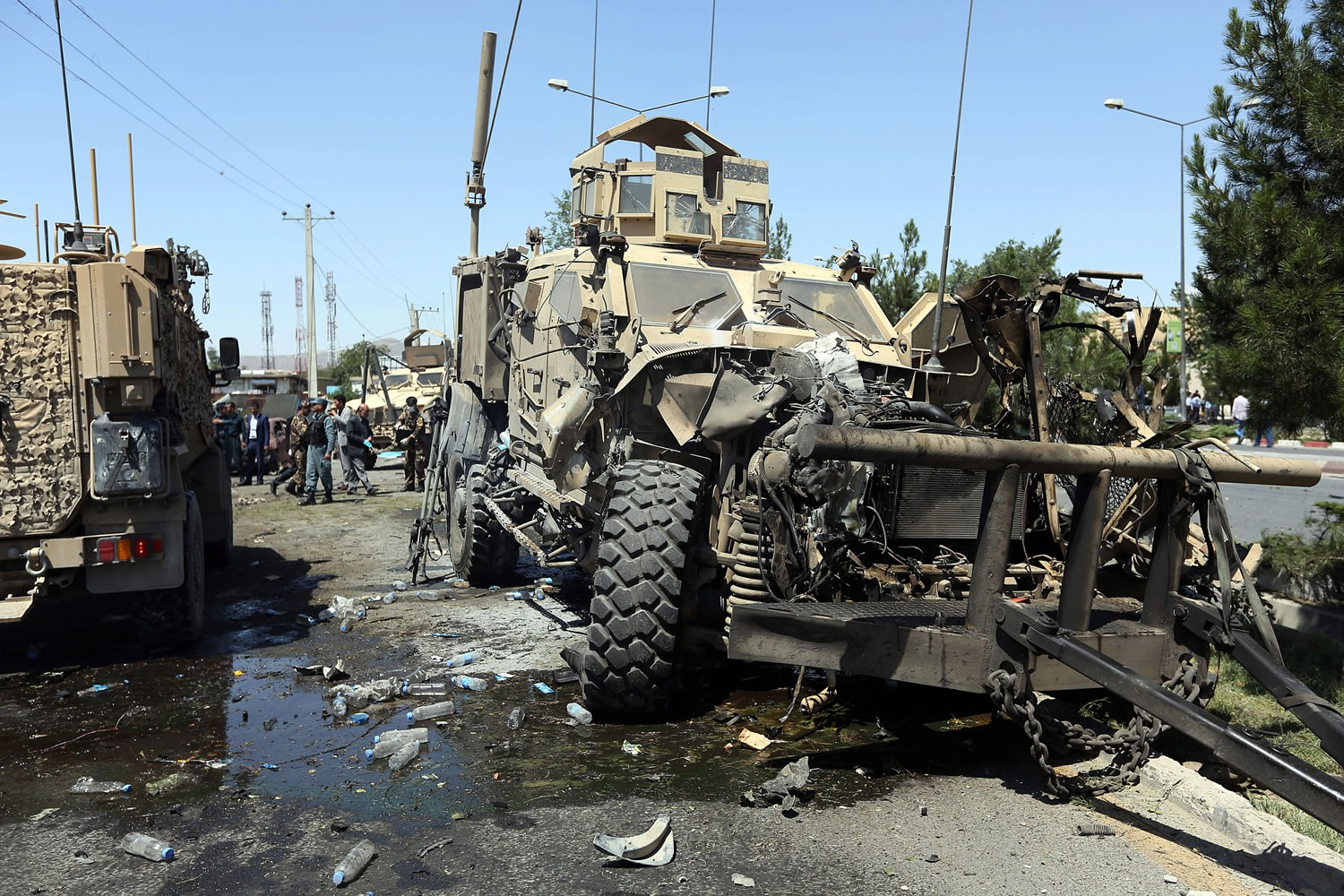 A destroyed armored vehicle remains at the site of a suicide attack on a NATO convoy in Kabul, Afghanistan, Tuesday, June 30, 2015. It comes a week after an audacious attack on the nation's parliament, which highlighted the ability of insurgents, who have been fighting to overthrow the Kabul government for almost 14 years, to enter the highly fortified capital to stage deadly attacks.