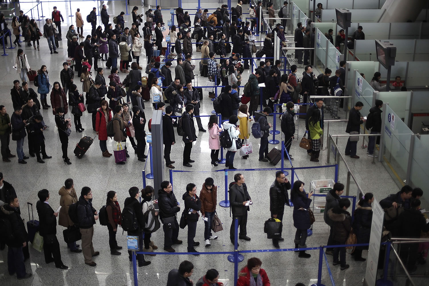 Passengers queue up for a security check at Pudong International Airport in Shanghai, China.