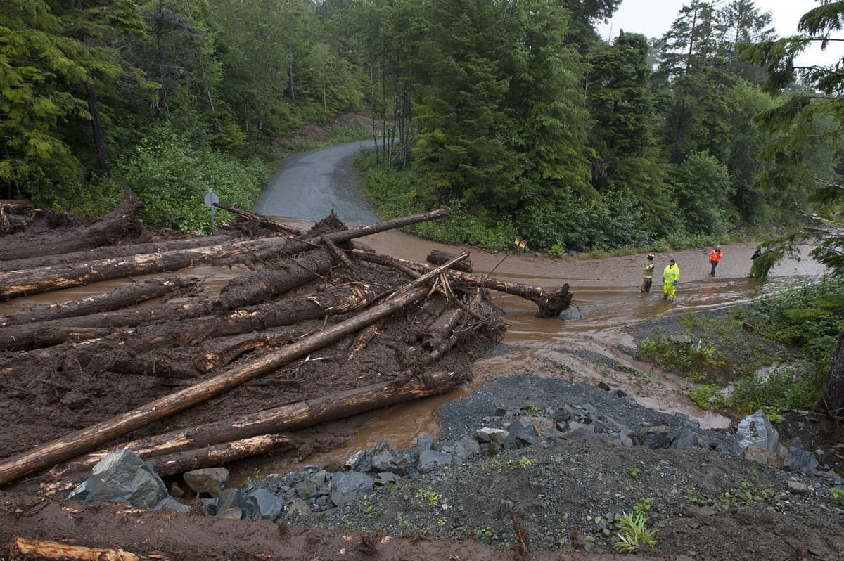 Construction workers and emergency crew members look at the damage caused by a landslide on Kramer Drive on Tuesday in Sitka, Alaska.