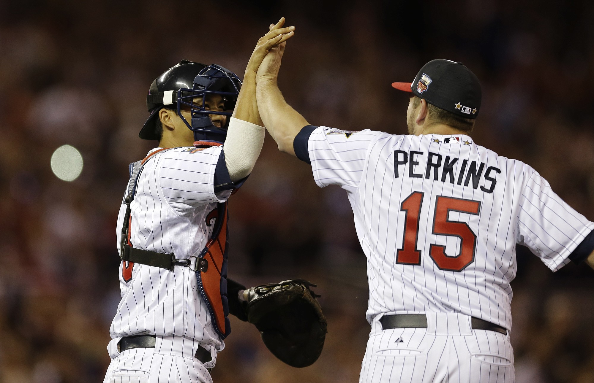 American League catcher Kurt Suzuki, of the Minnesota Twins, celebrates with American League pitcher pitcher Glen Perkins, of the Minnesota Twins, after their 5-3 victory in the MLB All-Star Game, Tuesday, July 15, 2014, in Minneapolis.