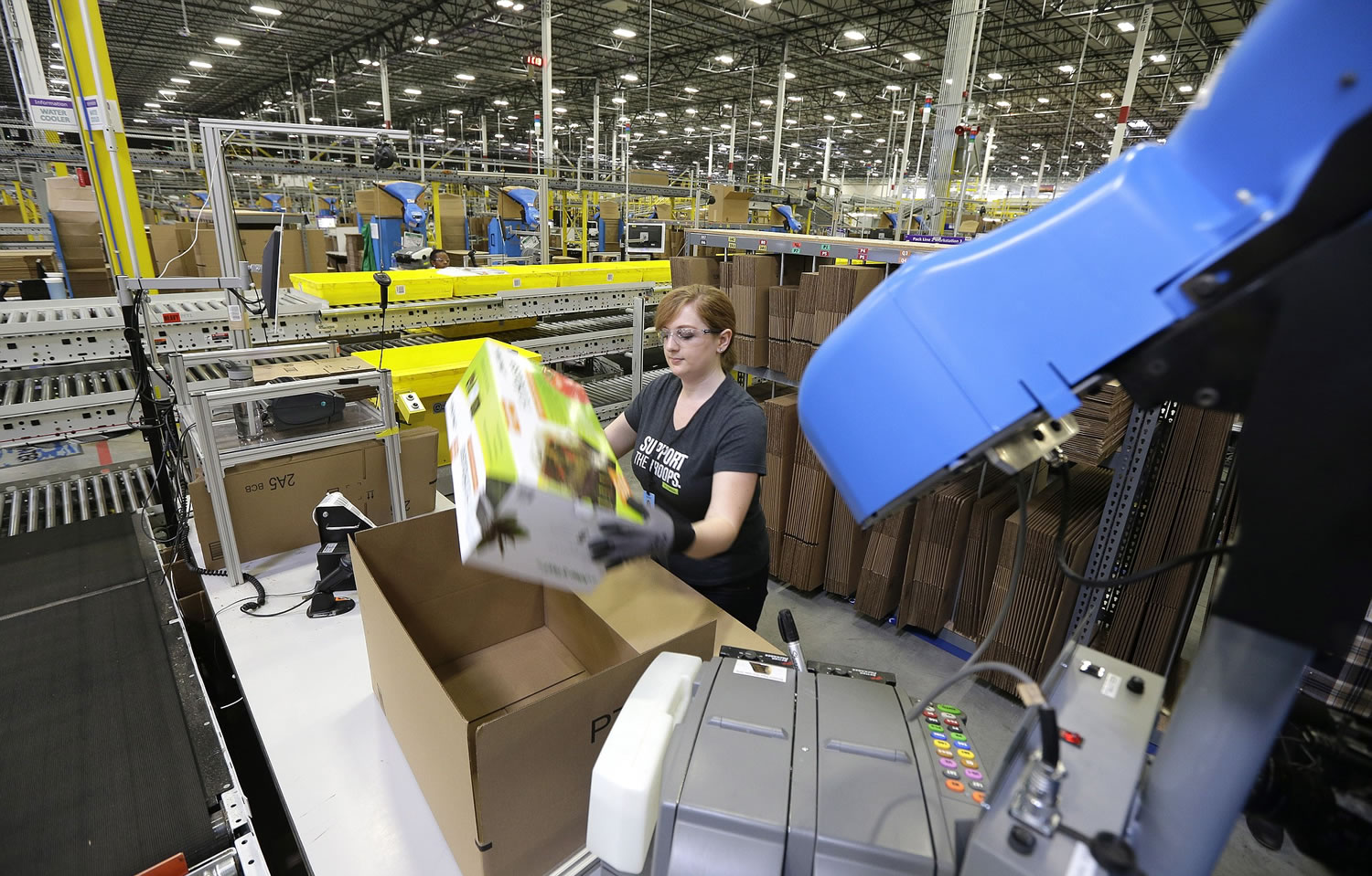 A worker places an item in a box for shipment Friday during a media tour of the new Amazon.com fulfillment center in DuPont.