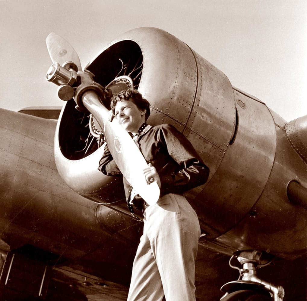 In this May 20, 1937 photo, provided by The Paragon Agency, shows aviator Amelia Earhart with her Electra plane's propeller, taken by Albert Bresnik at Burbank Airport in Burbank, Calif.
