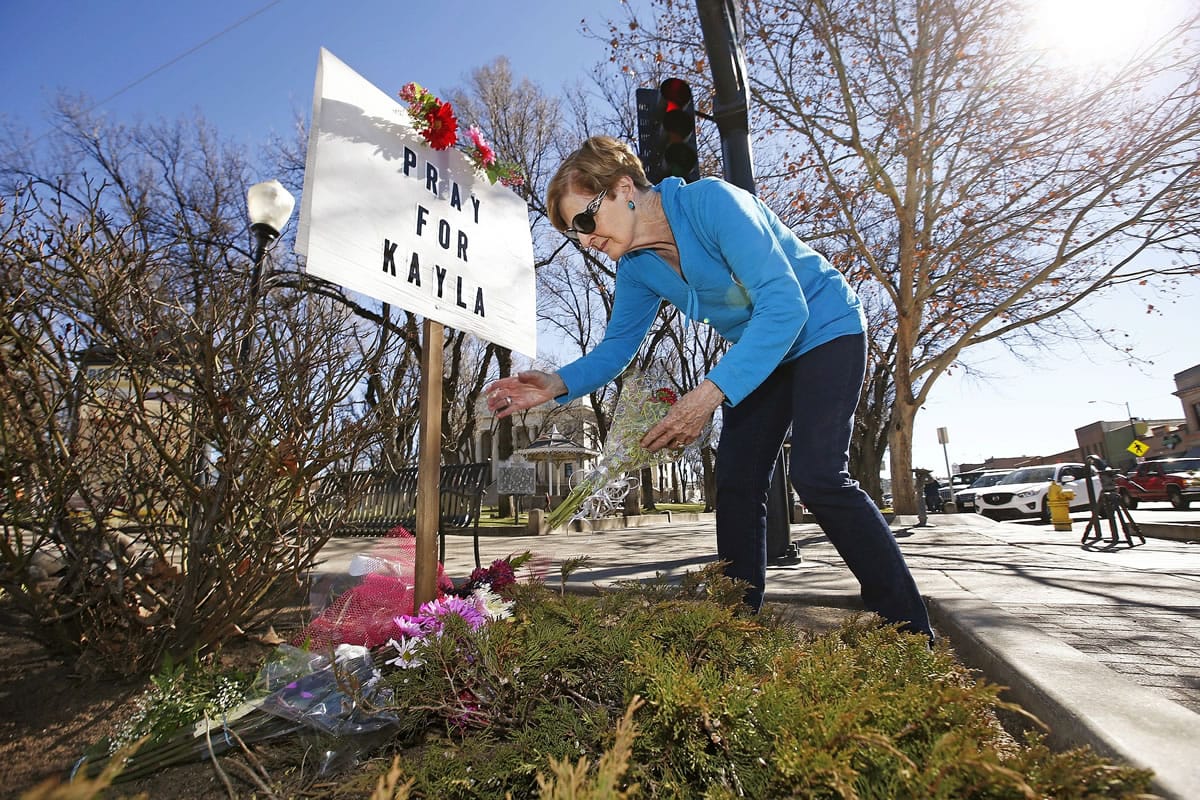 Turi Whiting of Minneapolis leaves a bouquet of flowers Monday at a &quot;Pray for Kayla&quot; sign in downtown Prescott, Ariz.