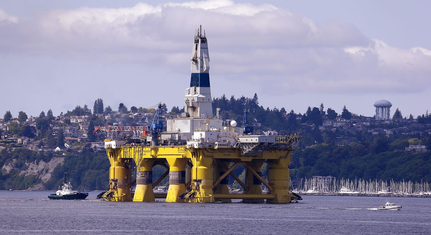The oil drilling rig Polar Pioneer is towed toward a dock Thursday, May 14, 2015, in Elliott Bay in Seattle. The rig is the first of two drilling rigs Royal Dutch Shell is outfitting for oil exploration and was towed to the Port of Seattle site despite the city's warning that it lacks permits and threats by kayaking environmentalists to paddle out in protest.
