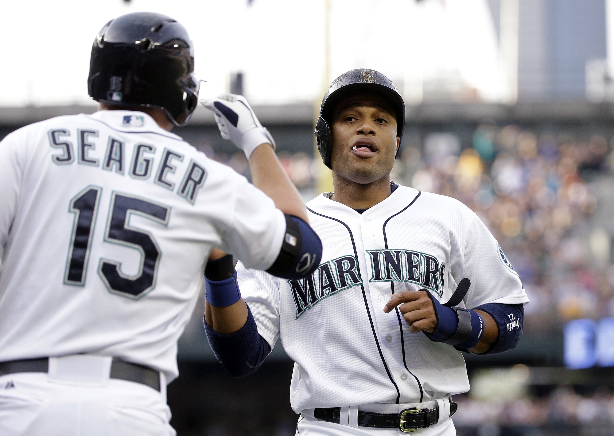 Seattle Mariners' Robinson Cano, right, is congratulated by Kyle Seager after scoring against the Oakland Athletics on Saturday, May 9, 2015, in Seattle.