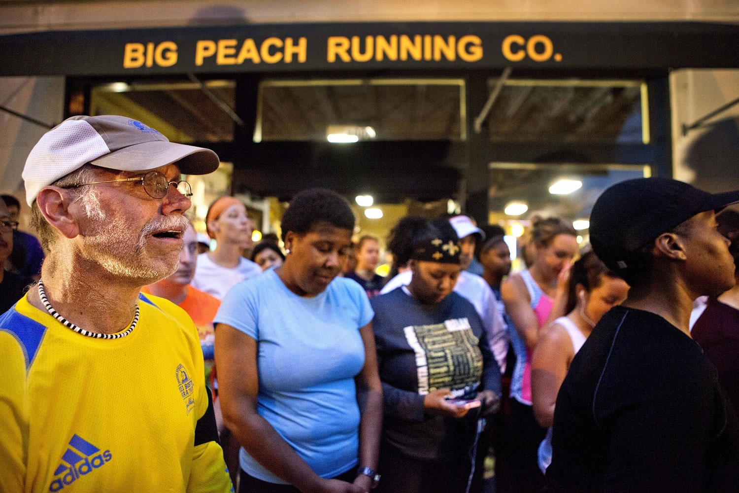 John Tackett of Atlanta, left, weeps during an organized moment of silence and memorial run to show solidarity with victims of the Boston Marathon bombing on Tuesday in Atlanta.
