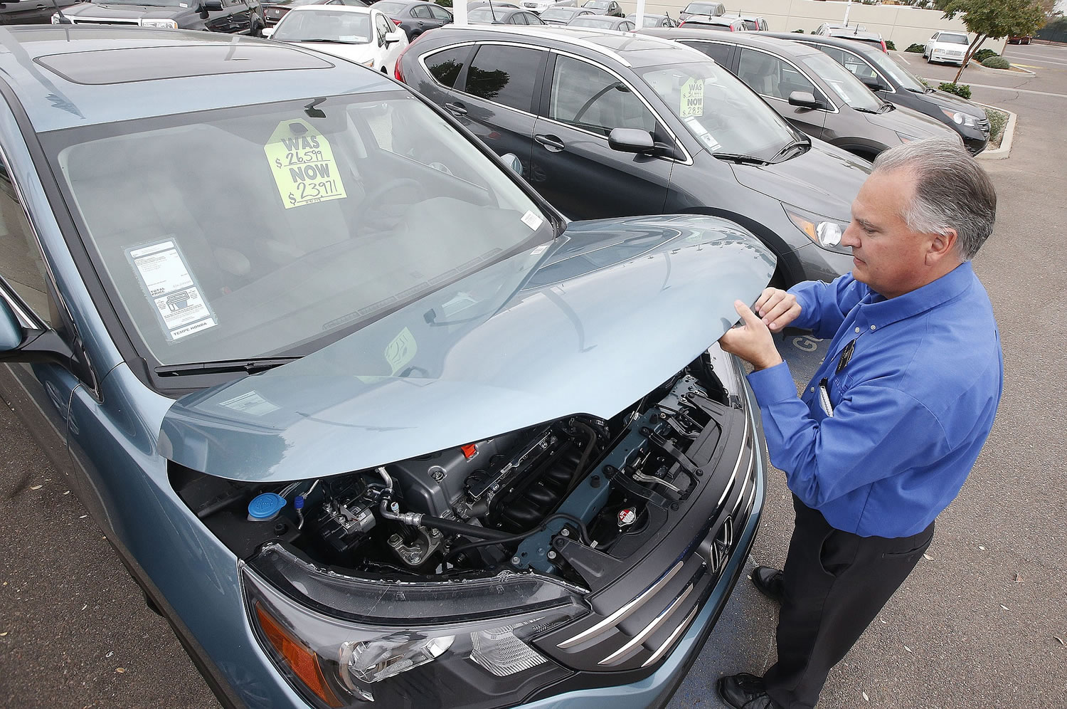 Associated Press files
Mike Johnson, a sales manager at a Honda car dealership, opens the hood of a Honda CRV in Tempe, Ariz.