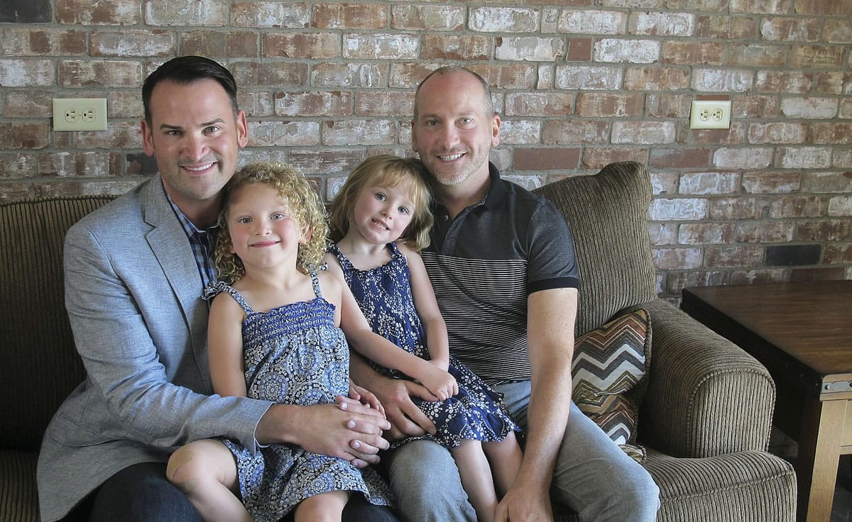 Matt Fleming, left, and Casey Jackson, right, sit with their twin daughters Bella and Lilah in their office Monday in Spokane. Fleming and Jackson are among thousands of registered domestic partners who will start the week married in the eyes of Washington state. under a component of Washingtonu2019s same-sex marriage law that was approved by voters at the end of 2012.