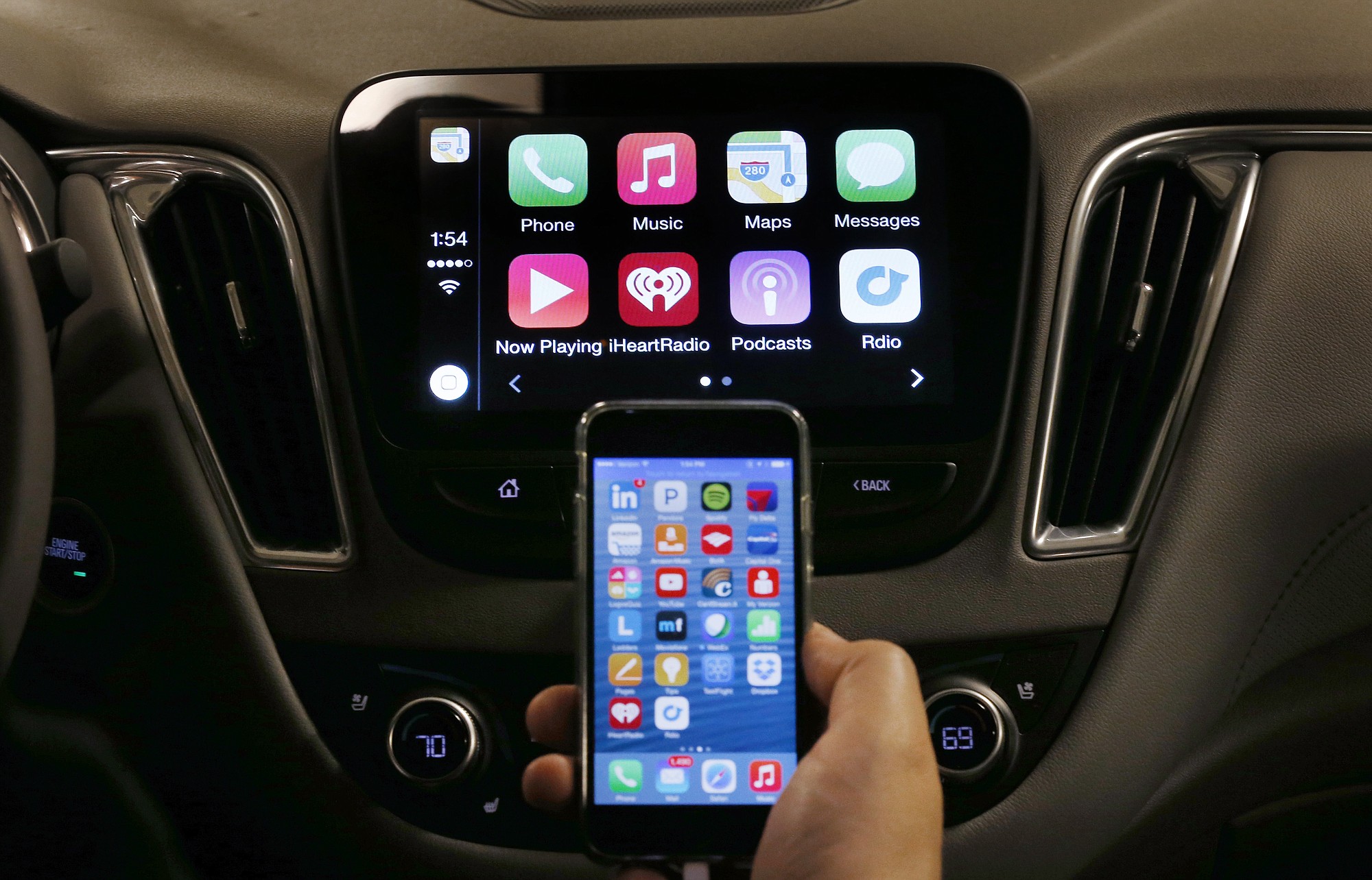 An iPhone is connected to a 2016 Chevrolet Malibu equipped with Apple CarPlay apps during a demonstration Tuesday in Detroit.