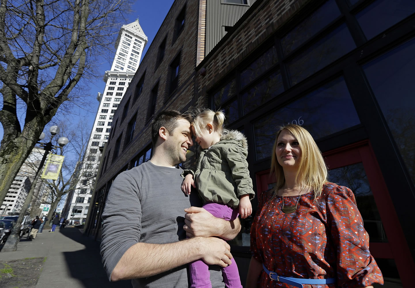 Jenny Kelly and her husband, Michael, share a smile with their daughter, Elea, 2, outside of their loft apartment building in Seattle's downtown Pioneer Square area.