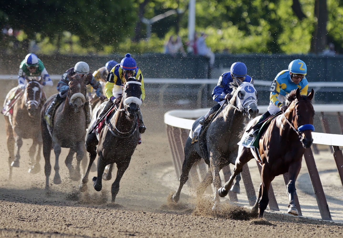 American Pharoah, with jockey Victor Espinoza, at right in blue and yellow, rounds the fourth turn ahead of the field at the Belmont Stakes on Saturday in Elmont, N.Y.
