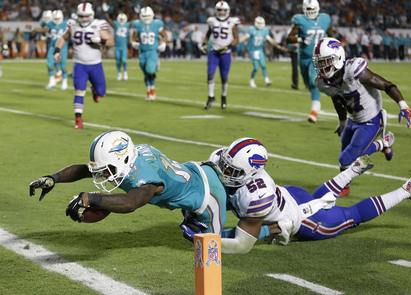 Miami Dolphins wide receiver Jarvis Landry (14) stretches out for a touchdown as he is tackled by Buffalo Bills inside linebacker Preston Brown (52) during the fourth quarter, Thursday, Nov. 13, 2014 in Miami Gardens, Fla.