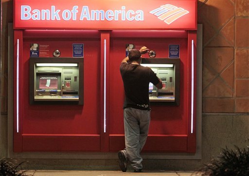 This photo taken Oct. 14, 2011, shows a customer at a Bank of America ATM in Hialeah, Fla. Bank of America Corp. is scrapping its plans to charge a $5 monthly debit card fee.