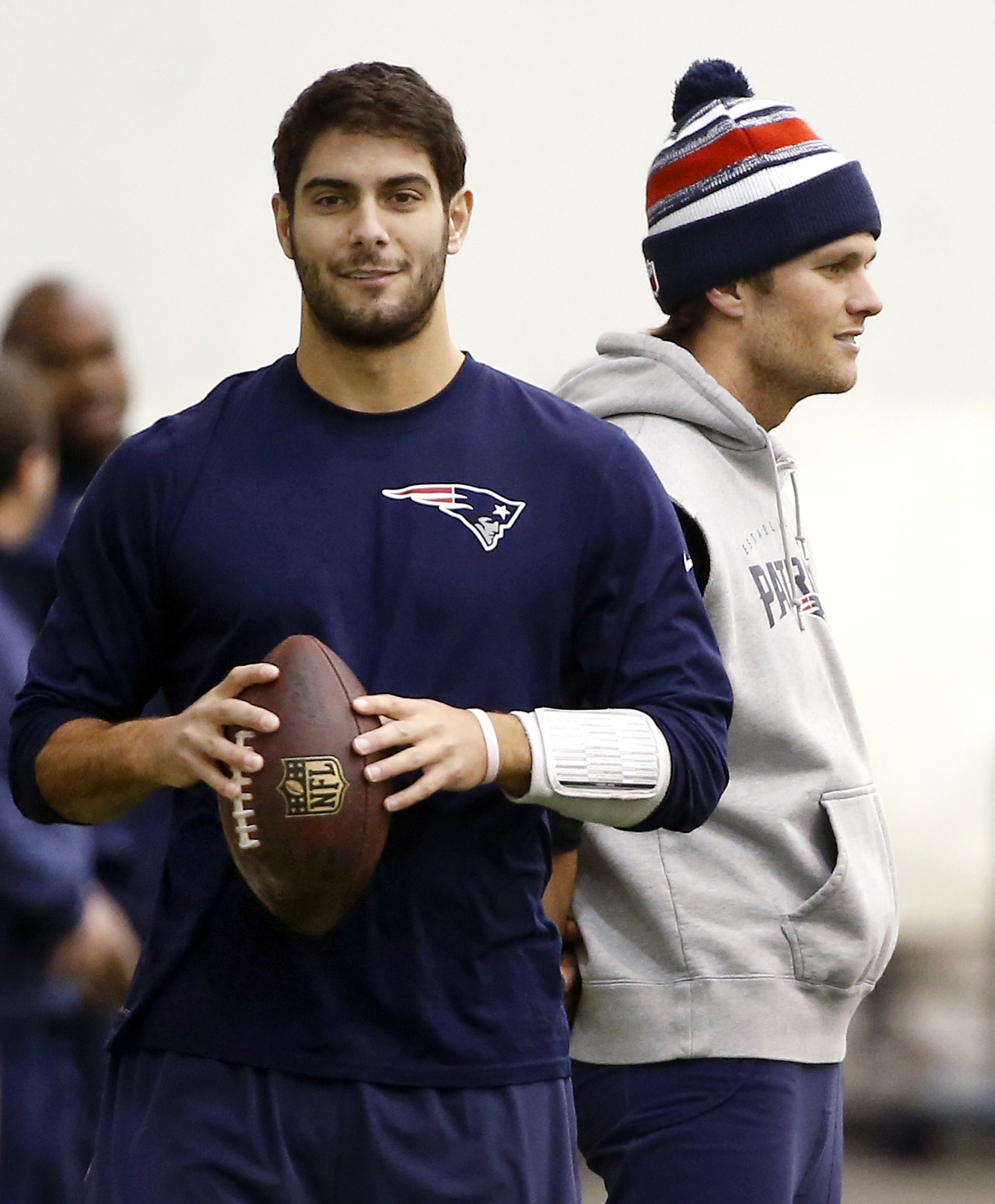 New England Patriots backup quarterback Jimmy Garoppolo, left, holds a football as starting quarterback Tom Brady, right, stands by during a walkthrough at the NFL football team's facility in Foxborough, Mass., in January.