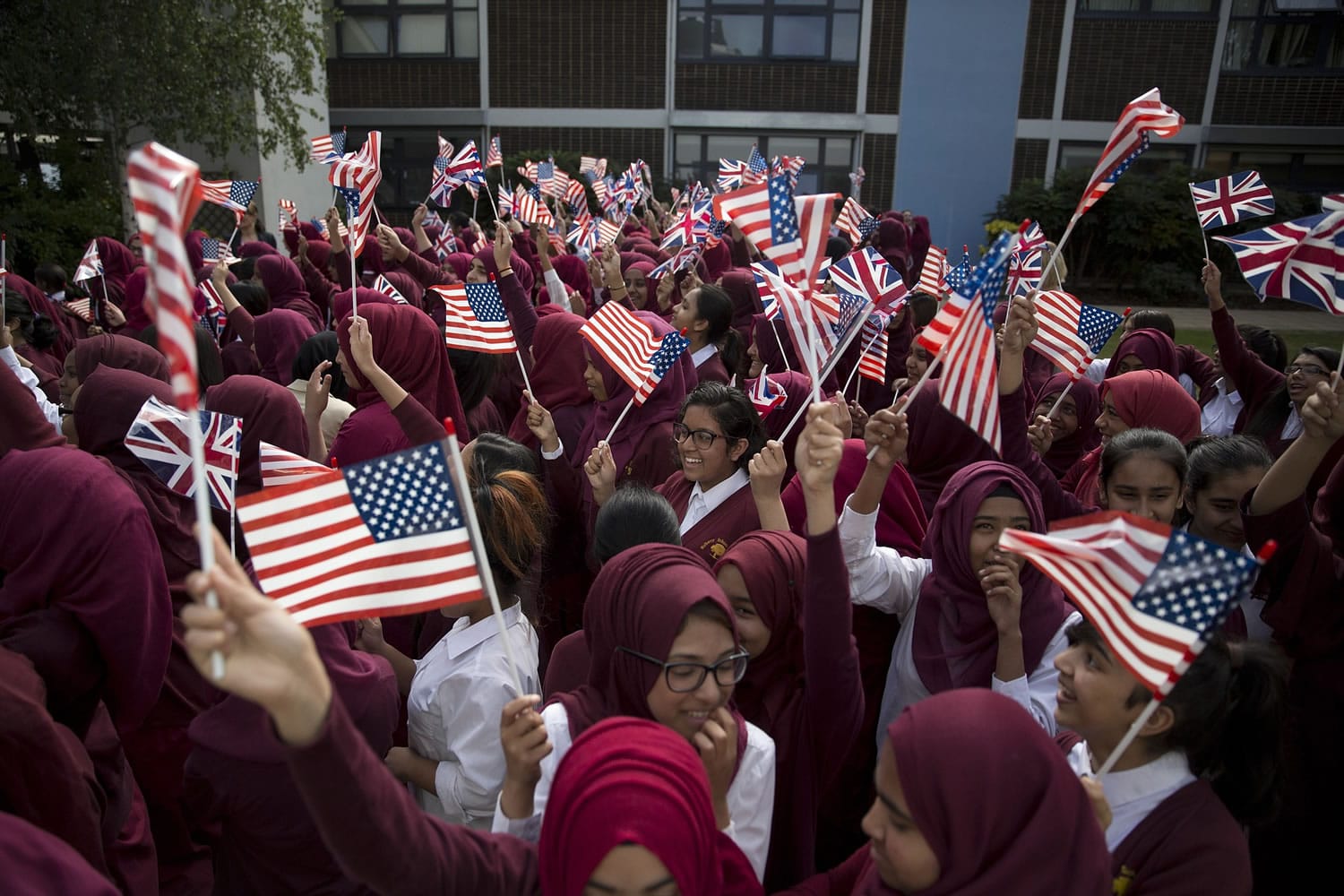 Students cheer and wave flags as they wait for the arrival of U.S. first lady Michelle Obama on her visit to Mulberry School for Girls in east London on Tuesday. Schoolgirls in east London greeted U.S.