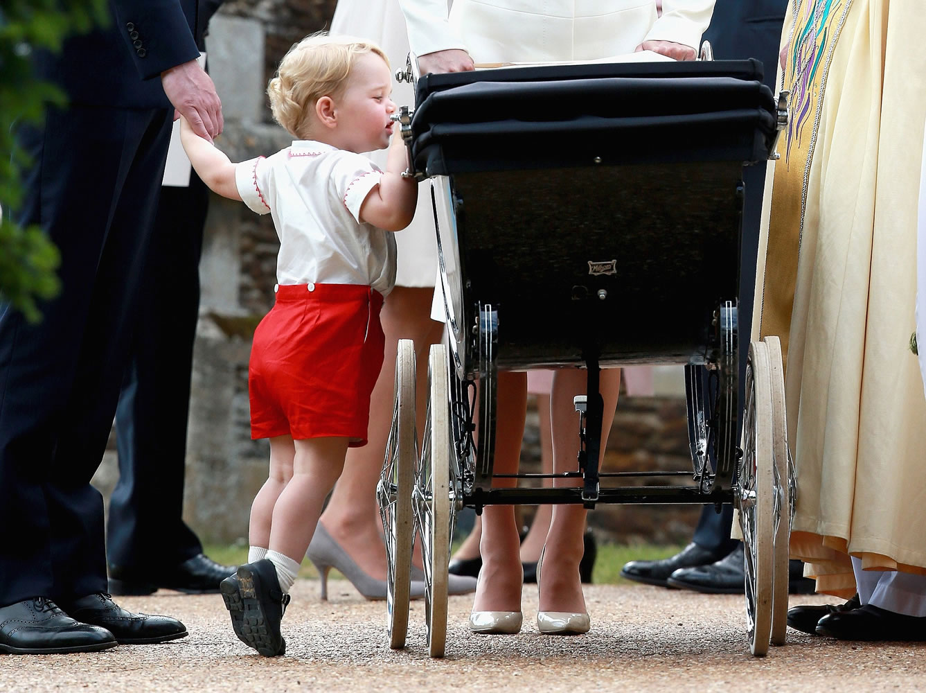 Britain's Prince George of Cambridge looks into the carriage carrying his sister, Princess Charlotte, as his family leaves the Church of St Mary Magdalene after her christening on the Sandringham Estate, England, on Sunday.